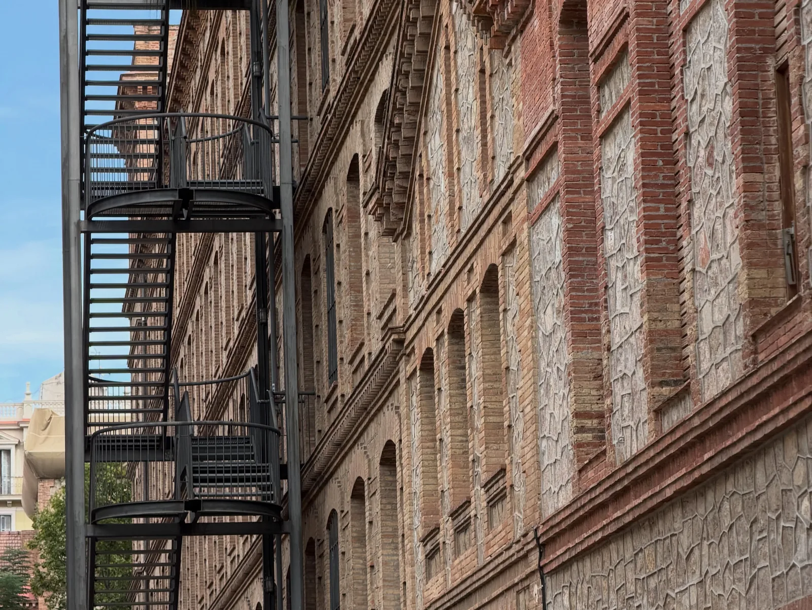 A brick façade with a black iron fire escape