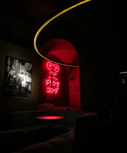 A pink neon in a dark bar