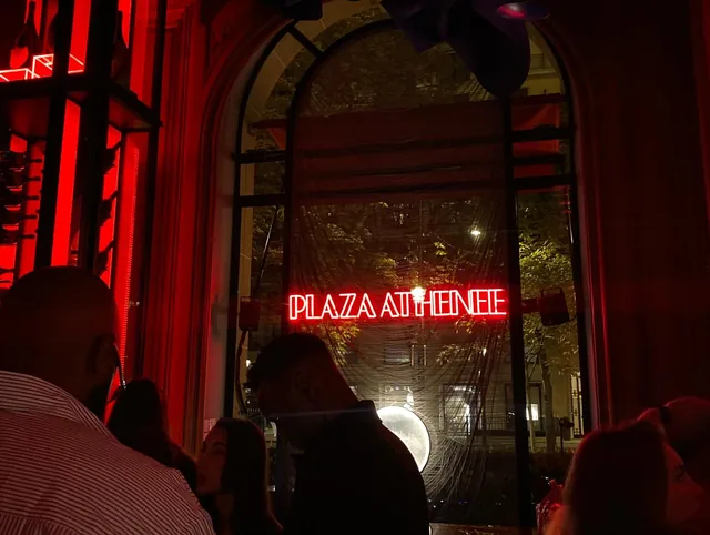 The Plaza Athénée sign through a window