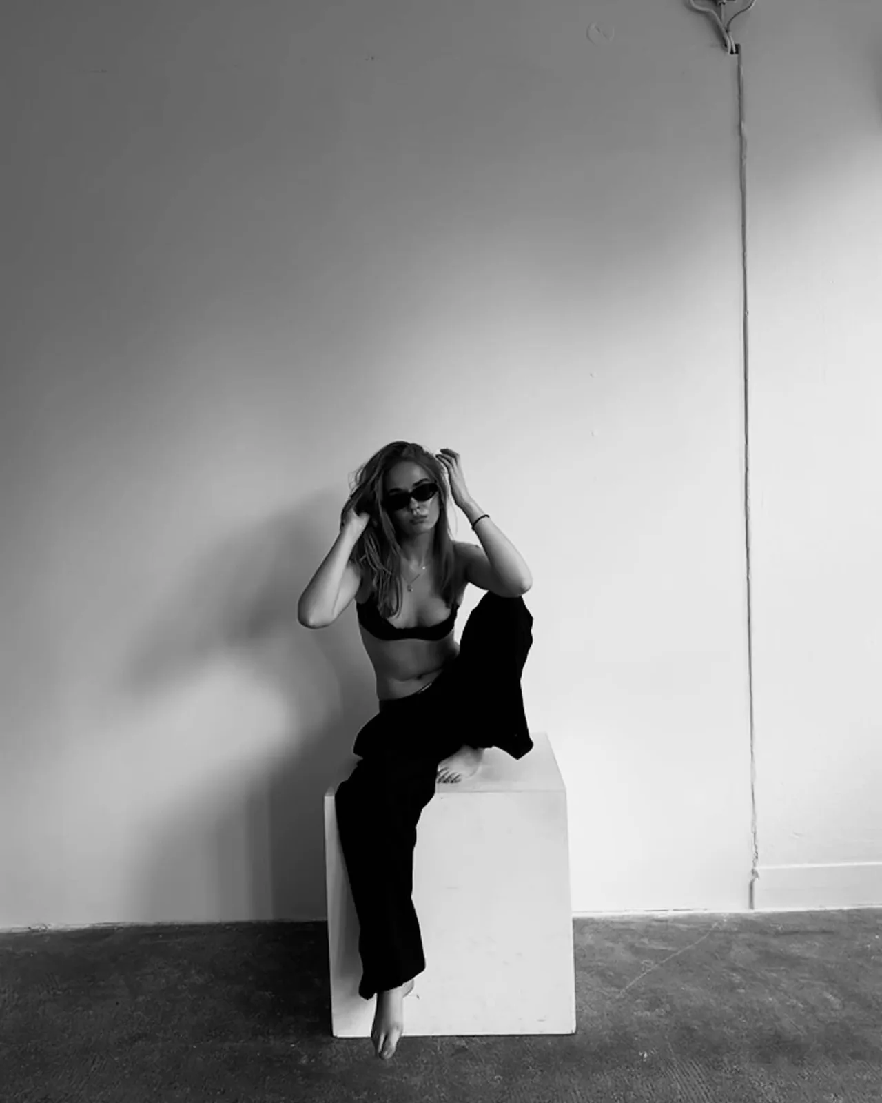 Studio, sitting on a white cube