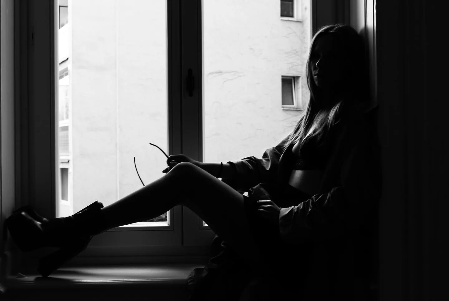 In silhouette at a window